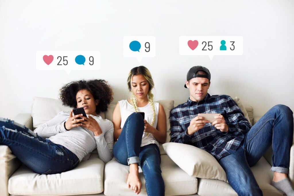 Young people sitting on the couch manipulating their smartphones